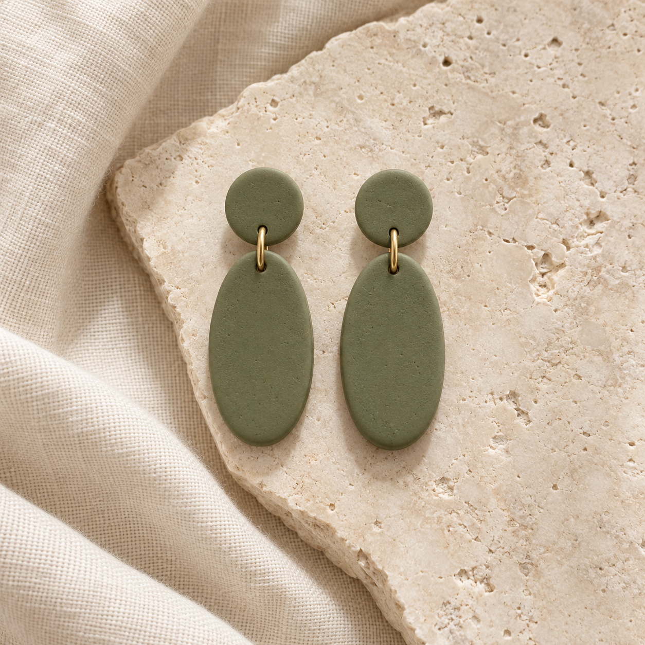 Modelo ilustrativo de pendientes ovalados verde oliva sobre un fondo natural