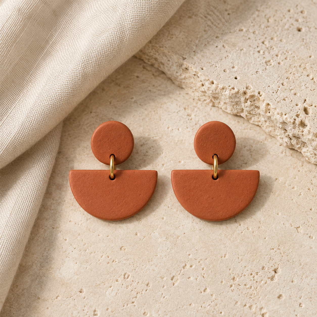 Modelo ilustrativo de pendientes de semicírculo terracota sobre un fondo natural